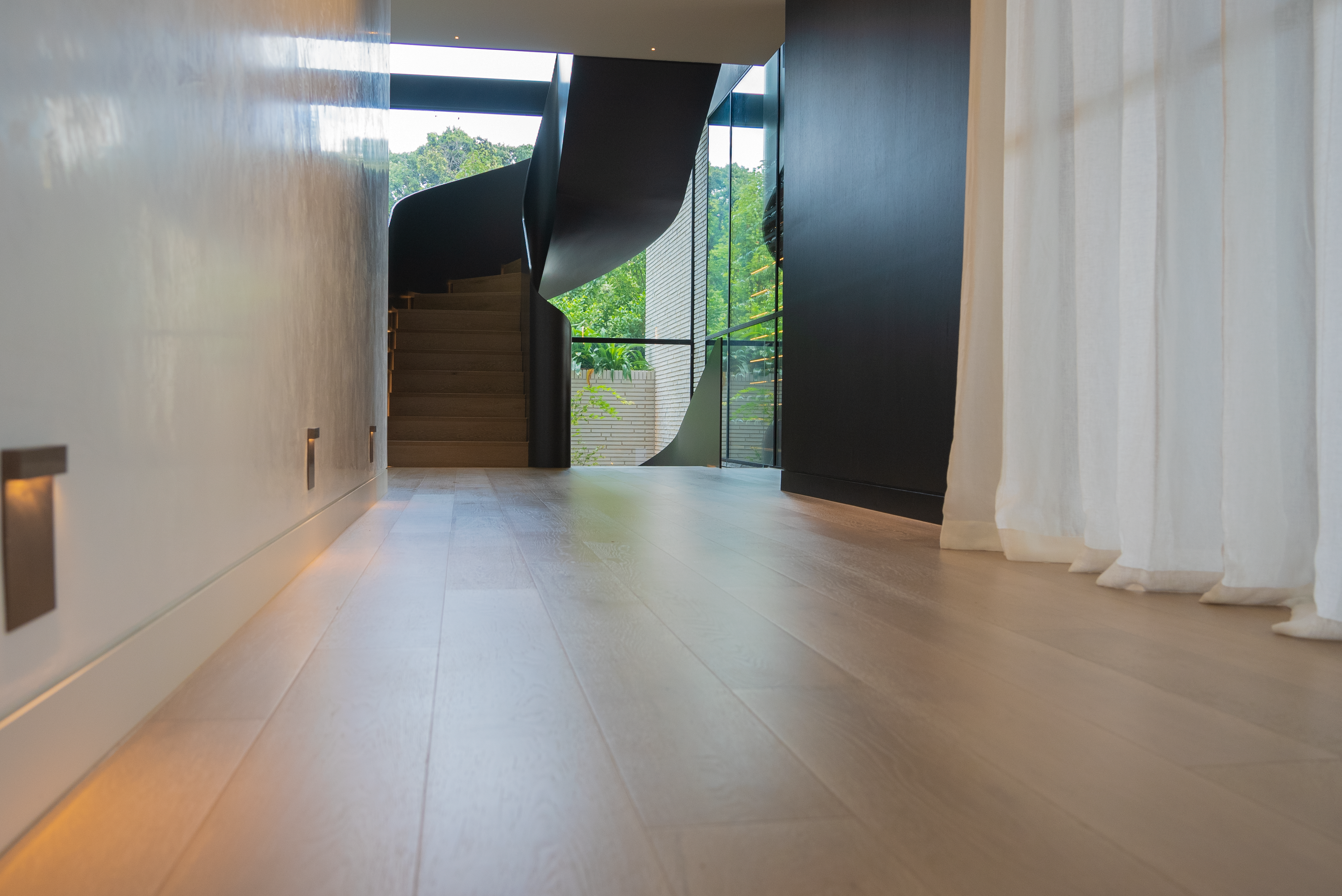 Dawn House &mdash; corridor with curvaceous steel staircase visible at the end